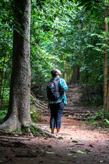 Woman with backpack exploring the beautiful rain forest on Sub madue Petchabun Thailand. Travel and ecotourism concept