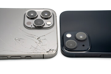 Close up of old destroyed smartphone vs. brand new isolated on white background