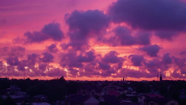 Time lapse of beautiful scenic red after the vibrant sunset over the city, fast moving clouds, cityscape, romantic red sky with pink afterglow, wide shot