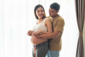 Fototapeta premium Young pregnant woman measuring belly centimeter, healthcare and pregnancy care