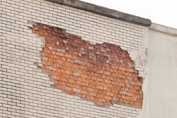 Brick brown red broken masonry wall with cement white concrete damaged facade background texture old