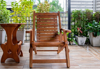 The reclining wooden chair on the terrace with the small garden.