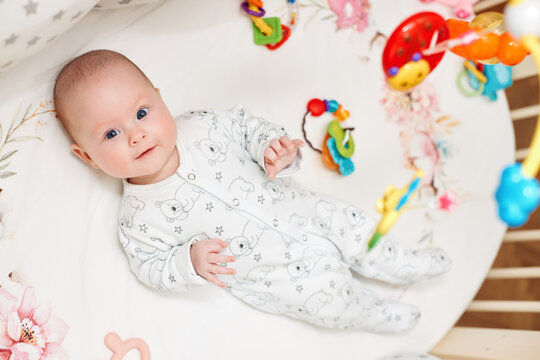 happy newborn baby in crib at home