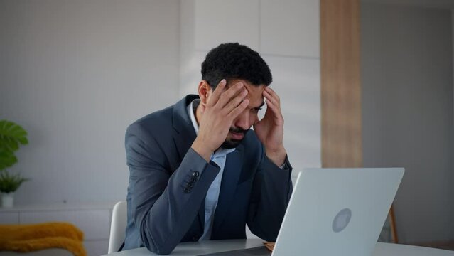Depressed businessman man counting euro money working on computer at office desk, inflation concept.