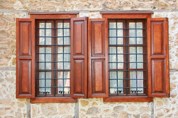 antique windows with metal bars in wooden frames on the facade of the building