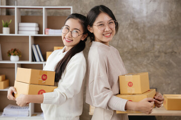 Two small business owner women hold the parcel b boxes ready to shipping and delivery to customers.