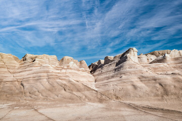 Fototapeta premium Famous rocks of Sarakiniko beach, Aegean sea, Milos island , Greece. No people, empty cliffs, summer sunshine, lunar landscape, deep blue sky, clouds