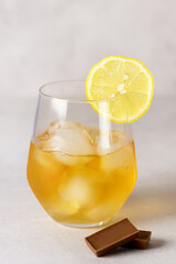 Closeup of Glass with Strong Drink and Snacks such as lemon and hocolate Vertical