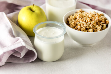 Portions of Fresh Natural Homemade Organic Yogurt Bowl of Granola Raw Apple Napkin Glass of Milk Breakfast Concept