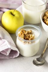 Portions of Fresh Natural Homemade Organic Yogurt Bowl of Granola Raw Apple Napkin Glass of Milk Breakfast Concept Vertical