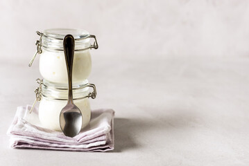 Two Portions of Fresh Natural Homemade Organic Yogurt in a Glass Jar Spoon Gray Background Copy...