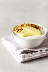 Yogurt With Granola and Raw Bowl in a White Bowl Healthy Breakfast Vertical