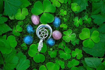 gemstones, witch amulet with pentagram and green leaves on natural forest background. crystals for...