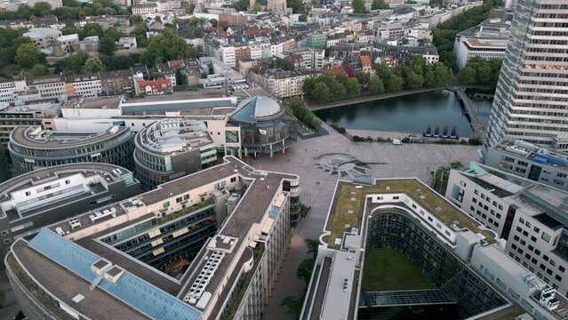 Cologne, Germany - Business Mediapark office buildings seen from aerial bird drone view in a calm and warm summer evening atmosphere showing buildings and a small lake, June 2022