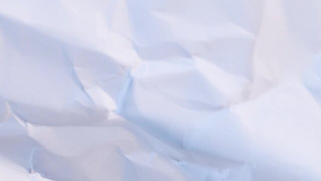 Wrinkled blank paper sheet rotating, close up view macro shot.