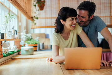Flirtatious middle aged couple using computer