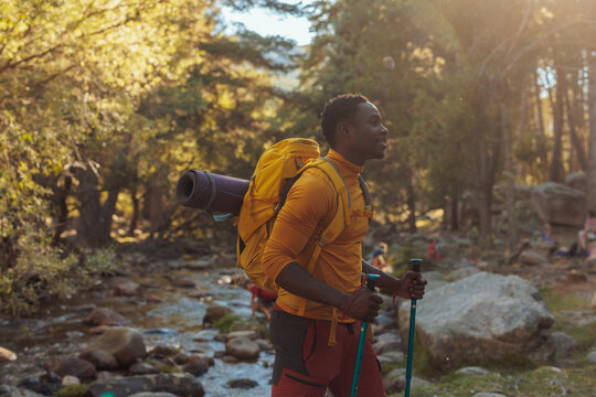 Young hiker crossing mountain stream