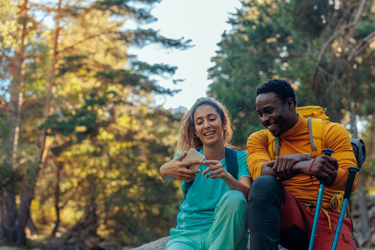 Young couple hiking is taking selfies in woods