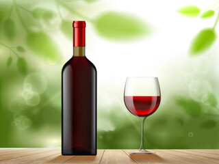 Bottle of red wine and a glass stand on a wooden table