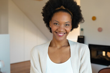 Portrait of smiling african american young afro woman at home, copy space
