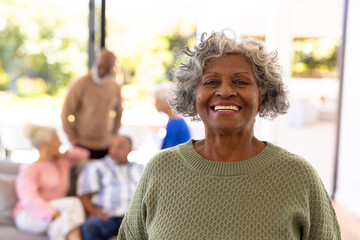 Portrait of smiling african american senior woman standing with multiracial friends in background - Powered by Adobe