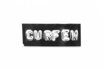 Black color banner that have embossed letter with word curfew on white paper background
