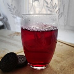 Compote of fresh berries in a transparent glass and cookies are on the table