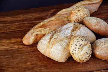 Assorted different types of bread on a wooden table, top view