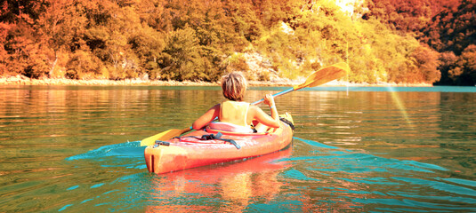 children canoeing in the river at sunset - obrazy, fototapety, plakaty