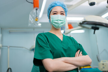 Portrait of Asian surgeon and nurse with medical mask standing with arms crossed in operation...