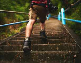 This trail is no challenge for him. Rearview shot of a man climbing stairs while hiking in the mountains.