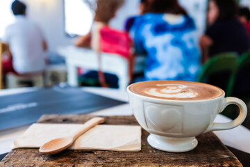 Hot latte art coffee in white cup on rustic table