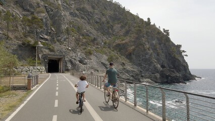 Italy , Liguria , June 2022 - Going bike from  Levanto Bonassola Framura cycle  pedestrian path - old galleries tunnels  in the rock by the sea - tourist attraction in the Cinque Terre - obrazy, fototapety, plakaty