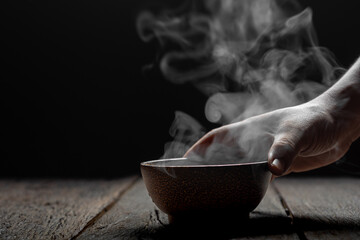 Steam of hot soup with smoke in a soup wood bowl bowl on wood table. Concept food Japanese or...