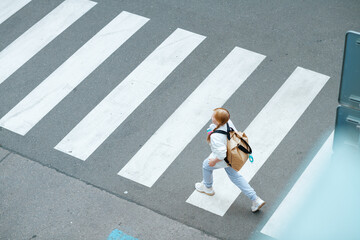 girl crossing crosswalk and going to school outdoors in city