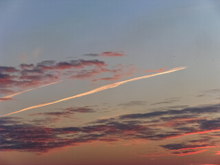 Overflying Planes Left a Turbulent Trail Against the Sky and Clouds, Illuminated by The Pink Rays...