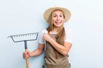 young adult blonde woman. farmer with a rake