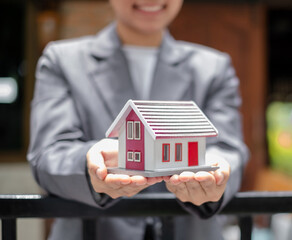 Agents working in real estate investing Agents' hands hold homes to protect the safety of customers, homebuyers, and new owners. Home and real estate insurance concepts