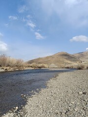 River Unfrozen before summer surrounded by rocky roads