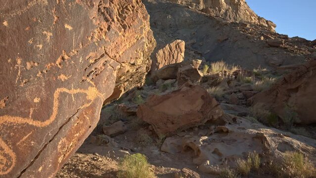 Wandering petroglyphs in Dray Wash in the Utah desert looking up the rocky cliffs.