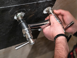 plumber adjusts eccentrics of shower faucet valve