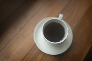 Coffee in a white mug in a restaurant with a view out the window