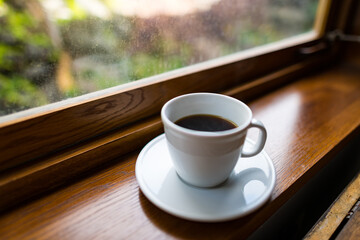 Coffee in a white mug in a restaurant with a view out the window