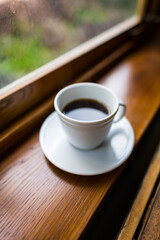Coffee in a white mug in a restaurant with a view out the window