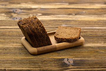 sliced rye bread in pieces in a wooden bowl on a wooden background