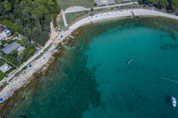 Aerial top view of a beach with turquoise blue green sea water of the adriatic sea, Rovinj, Croatia 