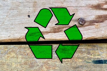 Green recycling symbol isolated on abandoned wooden materials background, recycle and reuse waste...
