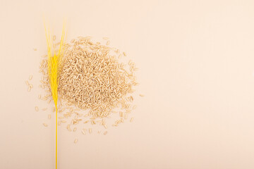 Brown rice spread in a minimalist style, on a beige-colore background. Top view