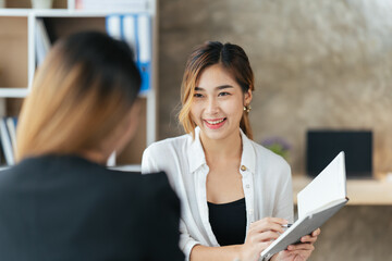Two business woman check report before presentation to customer, Business women at office desk...