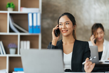 Portrait of happy lady typing in mobile while locating at desk in office, Young business woman on the phone at office.